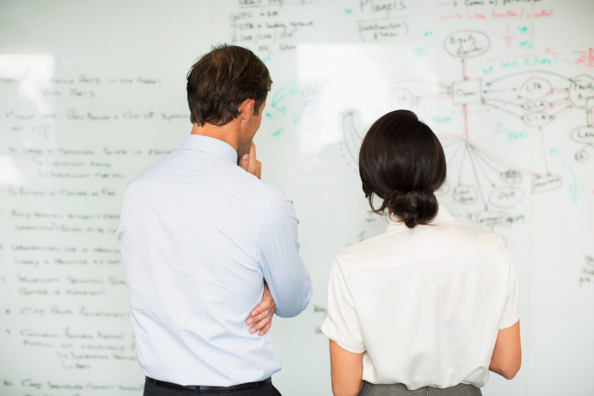 Business people reading whiteboard in office